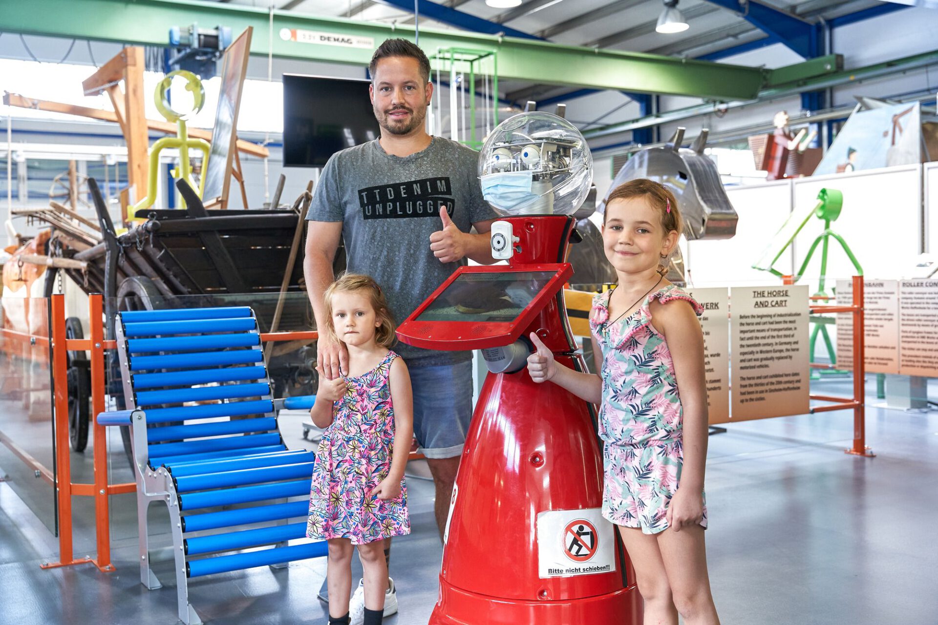 Familie mit Museumsroboter Nobby vor der Ausstellung